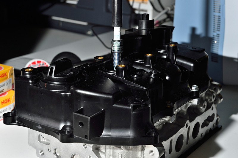 材質は硬質ゴム。最近はプラグの台座が奥まった位置にあるエンジンが多く、落下による碍子割れ防止と、プラグホールに斜めに入ったまま締め付けることによるネジ破損を防ぐ目的で、このように専用工具に差し込んでゆっくり確実に手締めするのだ