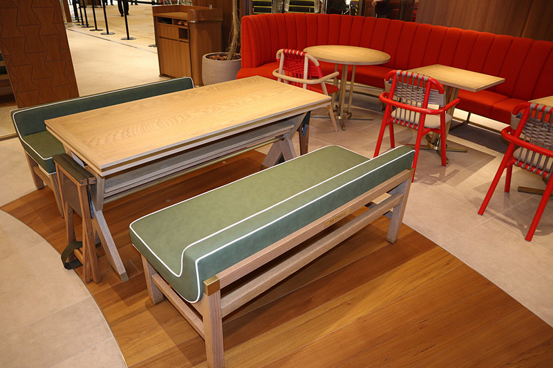 外周をぐるりと取り巻く赤いソファーのほか、ベンチタイプの4人掛けソファーも用意される