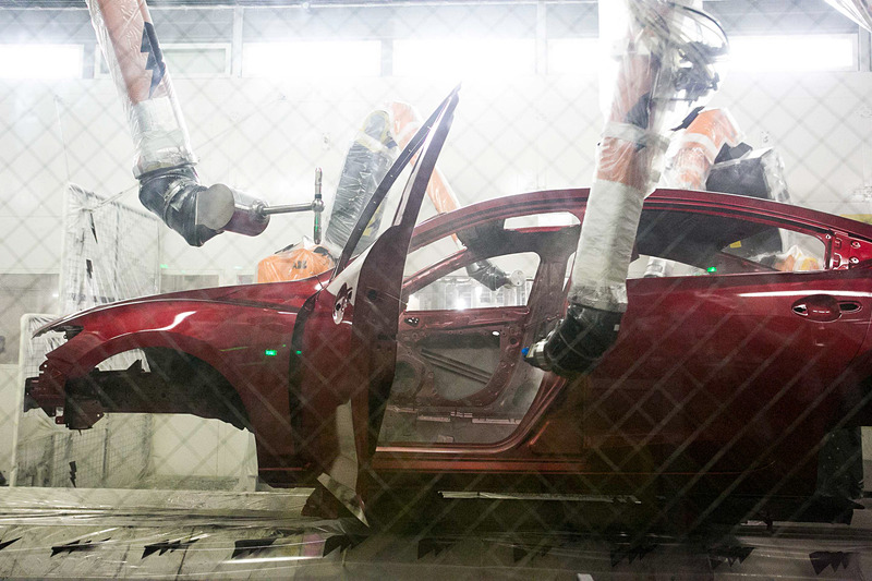 異なる色でも塗料が混ざることなく塗布できる塗装ライン。ホコリなどのゴミが塗装に入り込んでしまわないように機械は全てビニールで覆われていて、塗料が舞ってしまわないように風の流れも考えられている