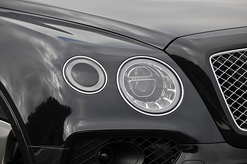 ベンテイガはベントレーのモデルとしてアルミモノコックボディを初採用。そのエクステリアでは丸目2灯タイプのヘッドライトを採用するほか、リアコンビネーションランプやフロントフェンダーのエアアウトレットなどにベントレーの「B」をモチーフにした造形を採用。撮影車のホイール＆タイヤはオプション設定の22インチアルミホイールにピレリ「P-ZERO」（285/40 ZR22）の組み合わせ