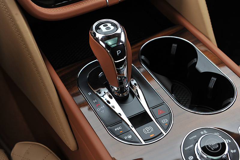 ベージュを基調とし、レザーやウッドパネルを贅沢に使用したインテリア。センターコンソールに8インチのタッチスクリーン式インフォテイメントシステムを標準装備するほか、ダッシュボード中央のアナログ時計が目を引く。センターコンソールには8種類のドライブモード（スポーツモード、ベントレーモード、コンフォートモード、カスタムモード、雪道/草地モード、泥道モード、砂利道モード、砂地モード）を統合制御する「ドライブダイナミクスコントロール」のコントロールダイヤルが備わる
