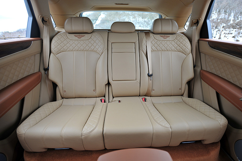 ベージュを基調とし、レザーやウッドパネルを贅沢に使用したインテリア。センターコンソールに8インチのタッチスクリーン式インフォテイメントシステムを標準装備するほか、ダッシュボード中央のアナログ時計が目を引く。センターコンソールには8種類のドライブモード（スポーツモード、ベントレーモード、コンフォートモード、カスタムモード、雪道/草地モード、泥道モード、砂利道モード、砂地モード）を統合制御する「ドライブダイナミクスコントロール」のコントロールダイヤルが備わる