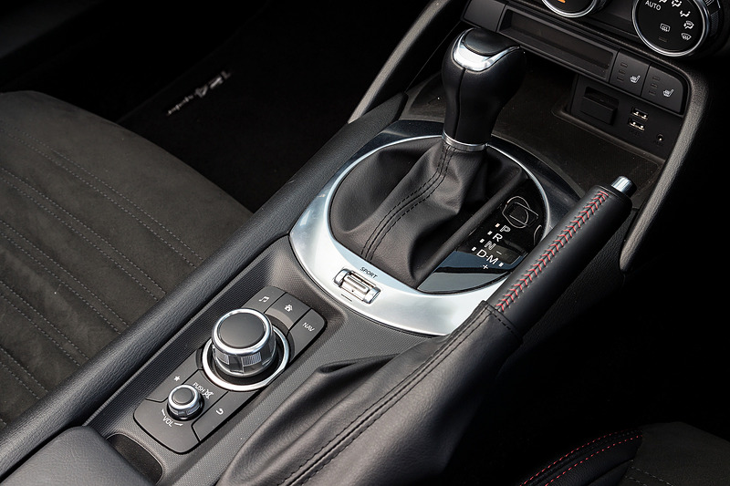 ブラックを基調に各所にレッドステッチなど赤色の加飾が与えられたアバルト 124 スパイダーのインテリア。アルミニウム製のペダル類、垂直に近いステアリングホイール、短いシフトレバーなどがスポーティなキャラクターを強調している