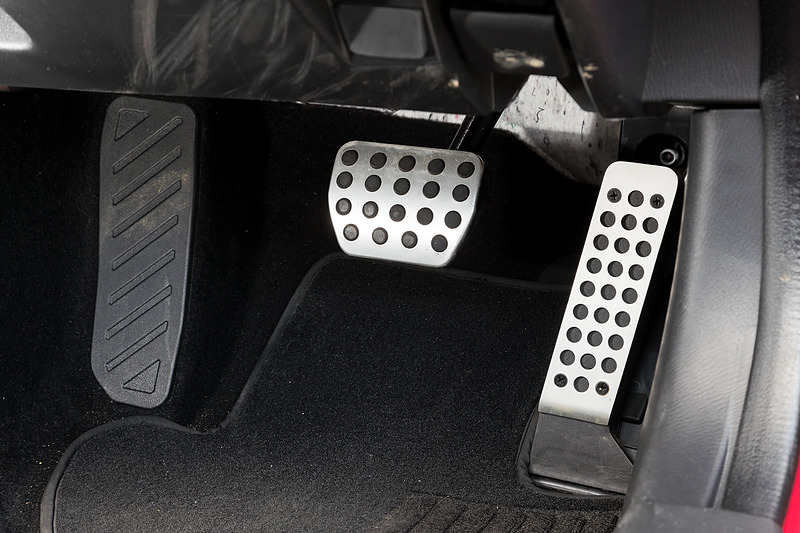 ブラックを基調に各所にレッドステッチなど赤色の加飾が与えられたアバルト 124 スパイダーのインテリア。アルミニウム製のペダル類、垂直に近いステアリングホイール、短いシフトレバーなどがスポーティなキャラクターを強調している