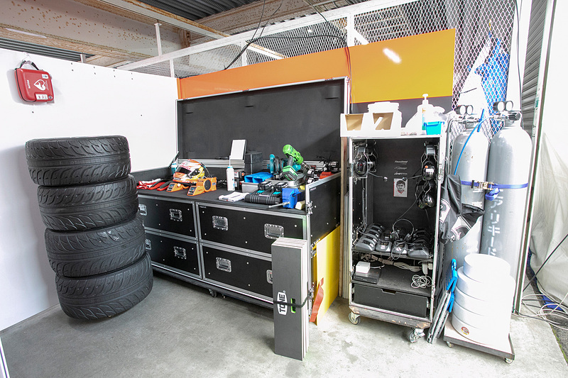 ピット奥、パーティションで仕切られている裏側。ドライバーの備品やチームで使っている無線機や充電器がある