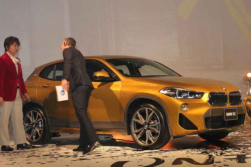 お披露目されたX2の外観を眺めた後、クロンシュナーブル氏に誘われてX2の運転席に座ってみる香取さん