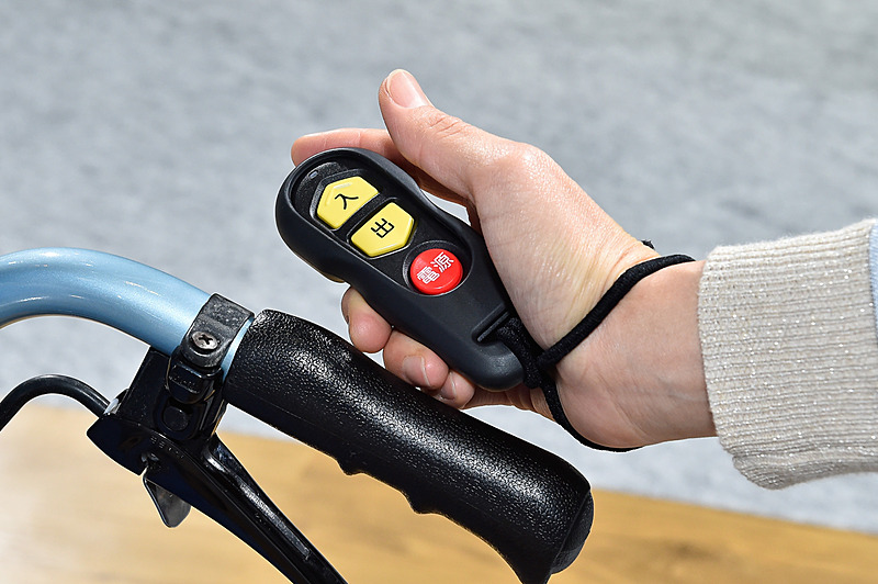 電動ウインチを操作するリモコンは、ベルトで車いすのハンドルに固定できるようになっている