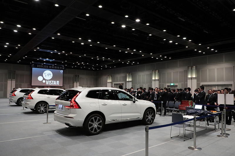 技術試験会場の様子。6台の「XC60 T8」（PHVモデル）が用意される。すべて同じ故障の設定。テクニシャン1名が対応し、制限時間55分の間に設定された設問に回答する。ただし、制限時間内に直しきることが目的ではなく、クルマの知識、診断スキル、機器の使い方、レポート内容などボルボの設定する手順をこなしているかを主に評価する