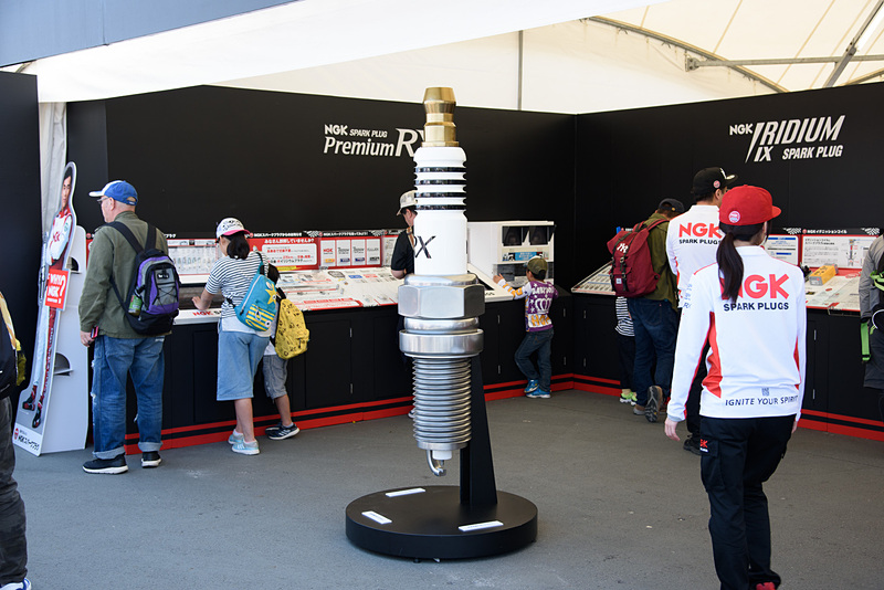 NGK スパークプラグ 鈴鹿2＆4レースの冠スポンサーとなっている日本特殊陶業のブース。巨大な「プレミアムRXプラグ」がお出迎え