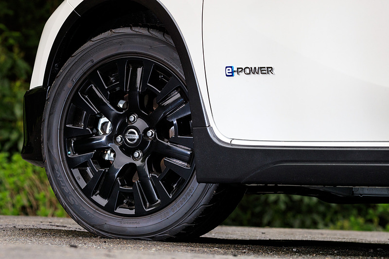 ノート C-Gearの標準モデルでは専用デザインのグロスブラック15インチアルミホイールが標準装備されるが、撮影車はオプションの「Touring Package」（8万6400円）に含まれるグロスブラック16インチアルミホイール（タイヤは3モデルともに195/55 R16サイズの横浜ゴム「DNA S.drive」）を装備