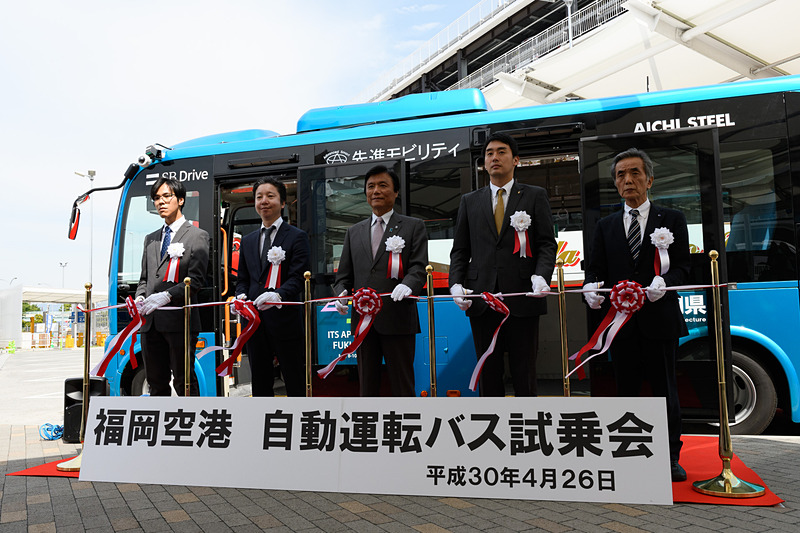 関係者によるテープカット。左から先進モビリティ株式会社 技術部主任 釘宮航氏、SBドライブ株式会社  COO 最高執行責任者 宮田証氏、福岡県知事 小川洋氏、福岡県議会議長代理 福岡県議会県土整備委員長 吉村悠氏、第16回アジア太平洋地域ITSフォーラム2018 福岡実行委員会事務局長 浦正勝氏