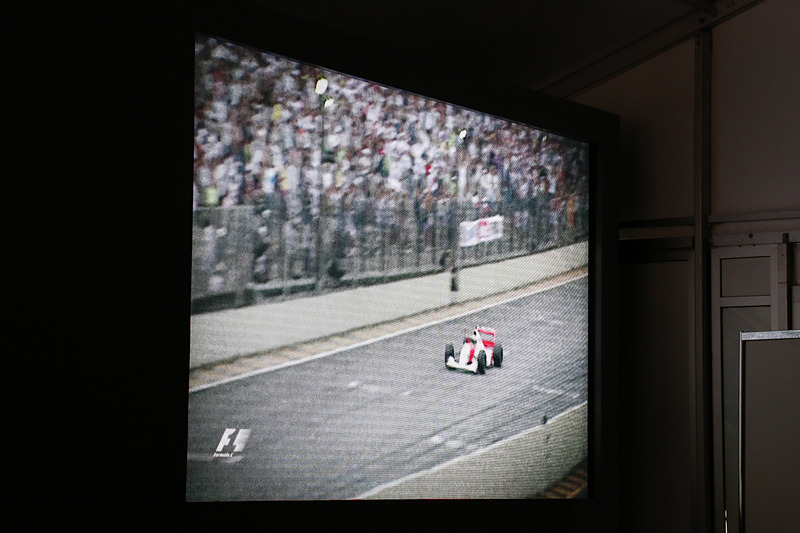 会場ではアイルトン・セナ選手がマクラーレンのF1マシンをドライブし、果敢なチャレンジで勝利を目指すシーンをムービーで紹介。チャレンジし続ける点を共通するDNAであるとした