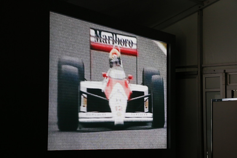 会場ではアイルトン・セナ選手がマクラーレンのF1マシンをドライブし、果敢なチャレンジで勝利を目指すシーンをムービーで紹介。チャレンジし続ける点を共通するDNAであるとした
