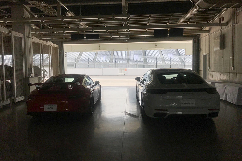 出番を待つGT3（左）と、パナメーラ E ハイブリッド（右）