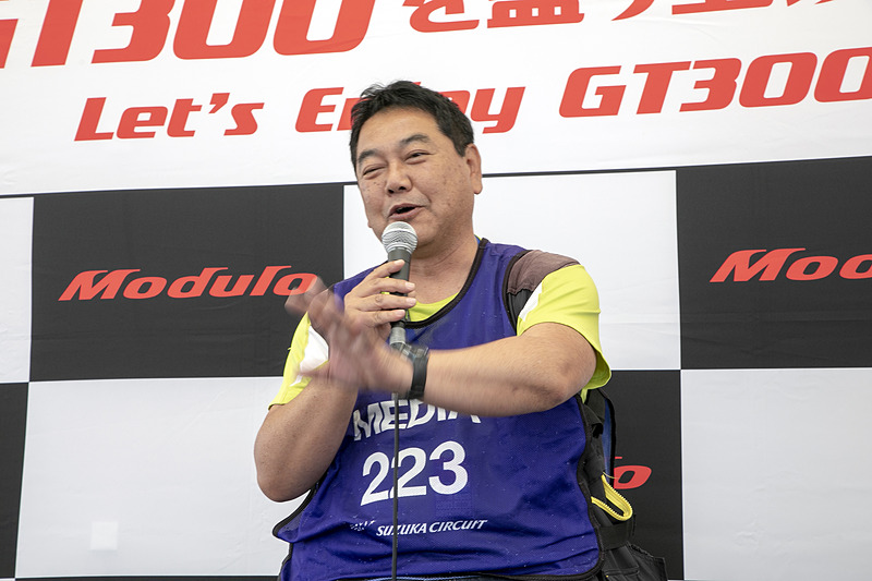 カメラマンの奥川浩彦氏。被写体としてのGT300クラスの魅力を語るカメラマン目線トークは、ステージ前の集まったカメラ好きから共感を得ていた
