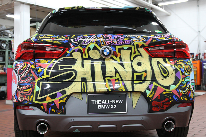 展示されるX2 ラッピング・カーのディテール。X2のコミュニケーションカラーであるゴールドが多用されている