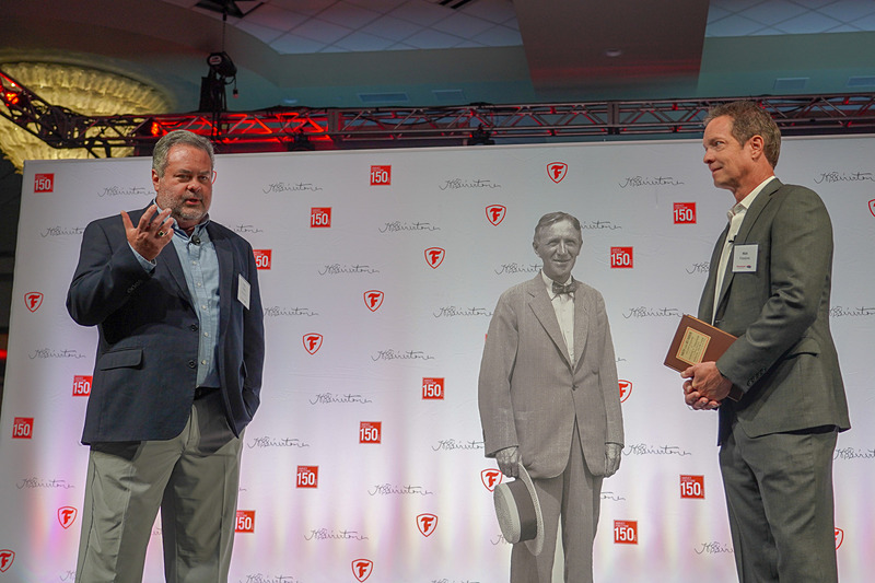 ペイシー氏（左）とニック・ファイアストン氏（右）の間にある等身大パネルが、ハーベイ・サミュエル・ファイアストン