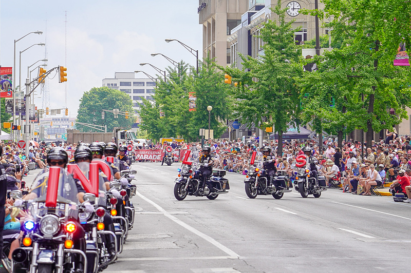 どこの国でも、パレードの最初は白バイ隊（こちらでは白くないが）と決まっているのか、地元警察のオートバイ部隊がINDIANAPOLIS 500の文字をバイクで表現