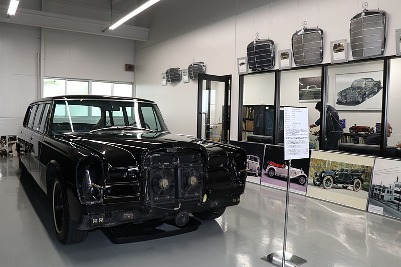 ヤナセ クラシックカー センターのサービス受け付けエリア。左側のピットスペースに対象となるクルマを駐車して、右側のスペースでオーナーから希望などを聞き取りする。2つのスペースの間にある壁に、ベンツ歴代モデルのフロントグリルが飾られていた