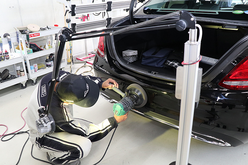 塗装後の研磨工程。イエローのスポットライトを当てて状態をチェックしながら作業していた