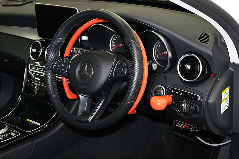 ステアリングに並行して設置されたオレンジ色のリングは手動運転用のアクセルリング。右手側にあるオレンジ色のノブはブレーキの操作用で、この2つを追加することで手動運転が可能になっている