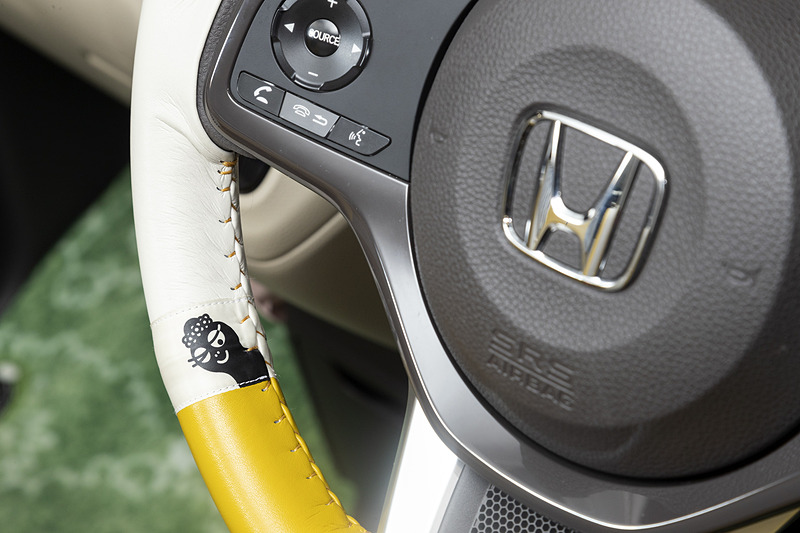 合皮製の「ステアリングホイールカバー」（1万800円）はアイボリーとマスタードイエローのコンビネーションタイプ。運転席に座ると、ステアリング内側に隠れているバーバママと目が合う