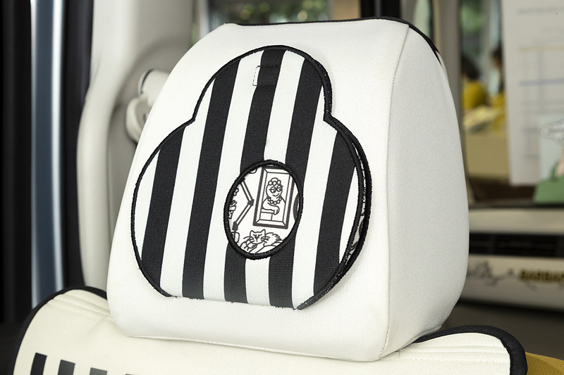 シートカバーのフロントヘッドレストは一部がめくれるようになっており、表のストライプと絵柄が変わる仕掛けが施されている。フラップに設定された穴は、めくって下げるとキックガードの「バーバズー」が顔を覗かせるといった遊び心がたっぷり