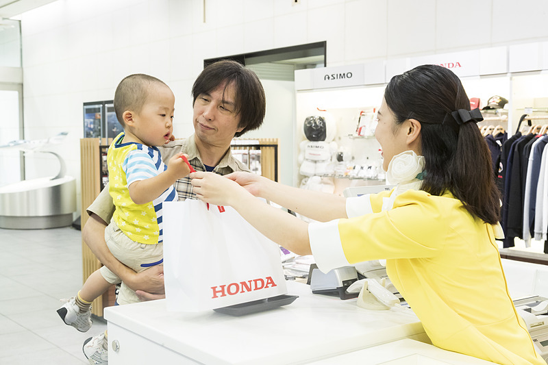 館内ショップでアシモのフィギュアを発見したマサナリは、真剣な表情で「どうしても欲しい」とおねだり。「ホンダスマイル」のお姉さんから無事に手渡してもらうことになったのでした
