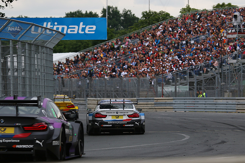 順位争いで連なるマシンを観戦する観客