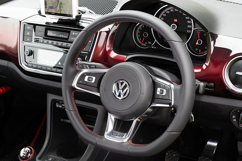 GTI専用のレザーマルチファンクションステアリングホイール、レザーシフトノブ、ドアシルプレートなどを装備するup! GTIのインテリア