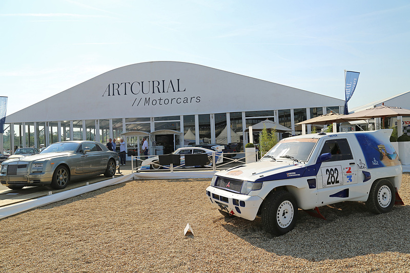 オークション会場前。オークションに出品されたパリ・ダカールラリーの三菱自動車工業「パジェロ」とランボルギーニのトラクター