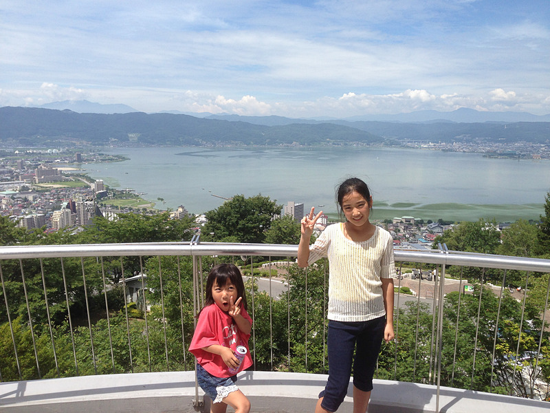 諏訪湖やアルプスの山々が一望できる、とってもきれいな立石公園からの眺め。テンションが上がって“ヘン顔”していた幼い姪っ子も、今ではすっかり大きくなりました（笑）。ここは駐車場も無料、遊具もすべて無料なのが嬉しいところです