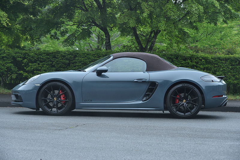 ブラウンカラーのソフトトップを開閉したところ。ボディサイズは4379×1801×1272mm（全長×全幅×全高）、ホイールベースは2475mm。6速MT仕様の車両重量は1375kg。「スポーツクロノパッケージ」に加え、機械式リアディファレンシャルロックを備えた「ポルシェ トルクベクトリング プラス（PTV Plus）」、車高を10mm低く設定する「ポルシェ・アクティブサスペンション・マネジメントシステム（PASM）」などを標準装備。ボディカラーはグラファイトブルーメタリック