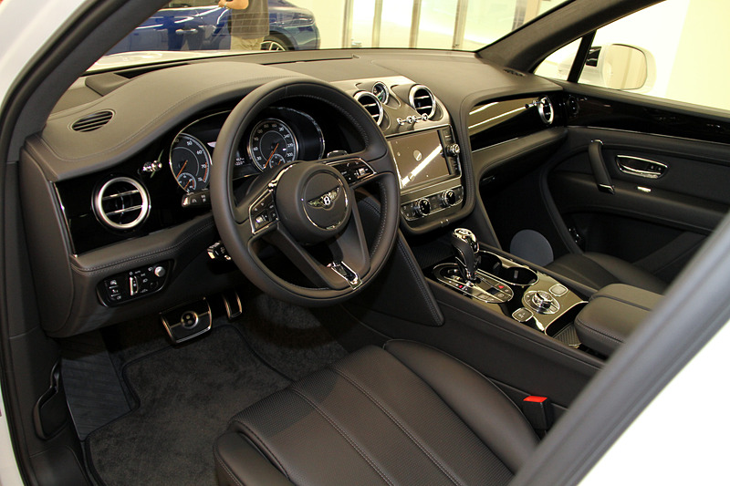 インテリアではベントレー初採用の「ハイグロスカーボンファイバー」の加飾パネル、ウッド＆レザーのステアリングホイールなどを採用