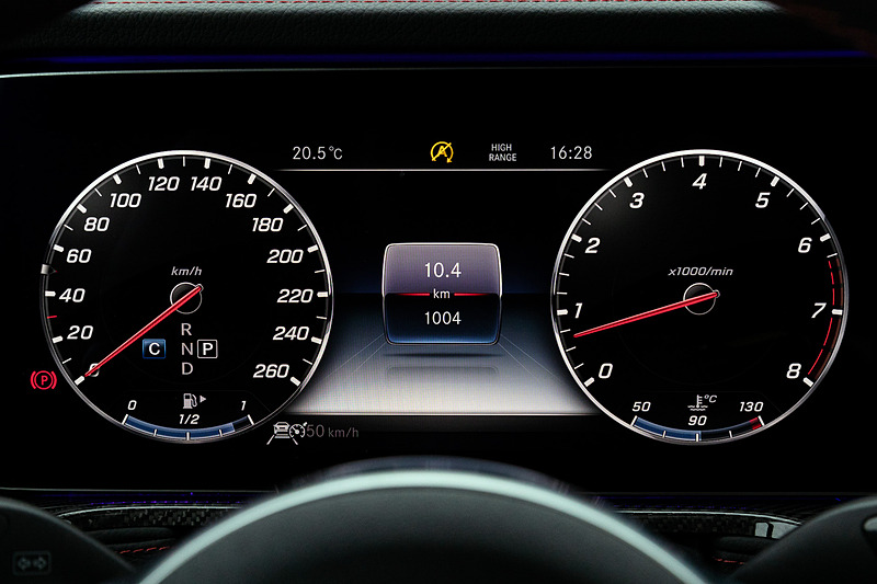 左右のエアアウトレットに特徴的な円形ヘッドライトの形状を採用するとともに、ウインカーをイメージしたスピーカーなどを装着。助手席前方のグラブハンドルや、3つのディファレンシャルロックを操作するクローム仕上げのスイッチなどは新型でも継承する一方で、厳選されたレザーや上質なウッドトリム、随所に施されたシルバー加飾などを用いることでラグジュアリーさも強調