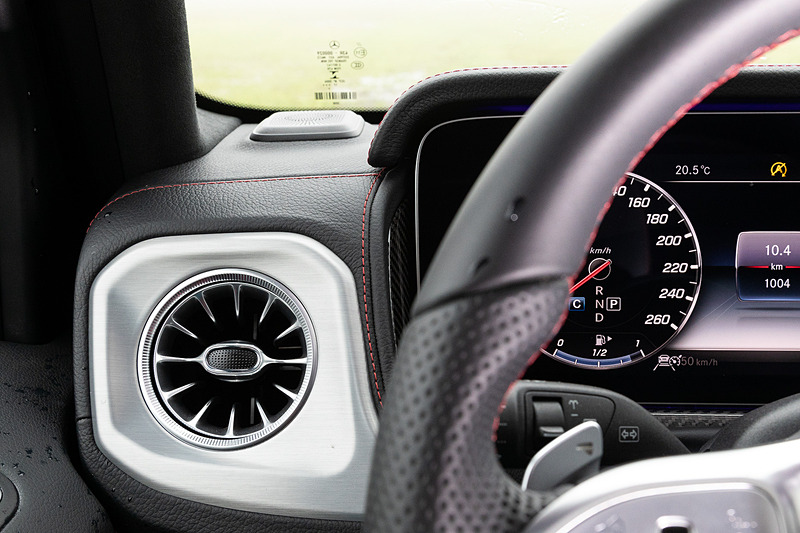 左右のエアアウトレットに特徴的な円形ヘッドライトの形状を採用するとともに、ウインカーをイメージしたスピーカーなどを装着。助手席前方のグラブハンドルや、3つのディファレンシャルロックを操作するクローム仕上げのスイッチなどは新型でも継承する一方で、厳選されたレザーや上質なウッドトリム、随所に施されたシルバー加飾などを用いることでラグジュアリーさも強調