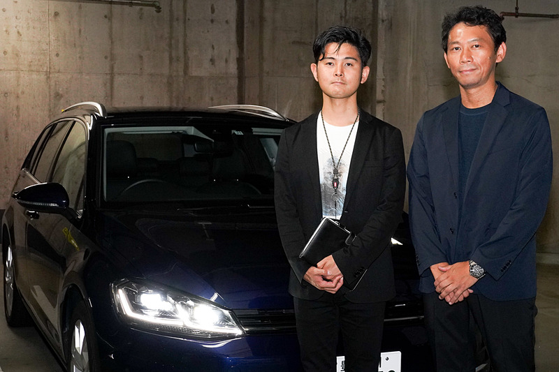 レイヤードサウンドのデモカーの前で。写真左から、フォルクスワーゲン グループ ジャパン株式会社 アフターセールス本部 販売促進課 富内眞悟氏と、レイヤードサウンド・セールス＆マーケティング株式会社 代表取締役 佐藤大氏