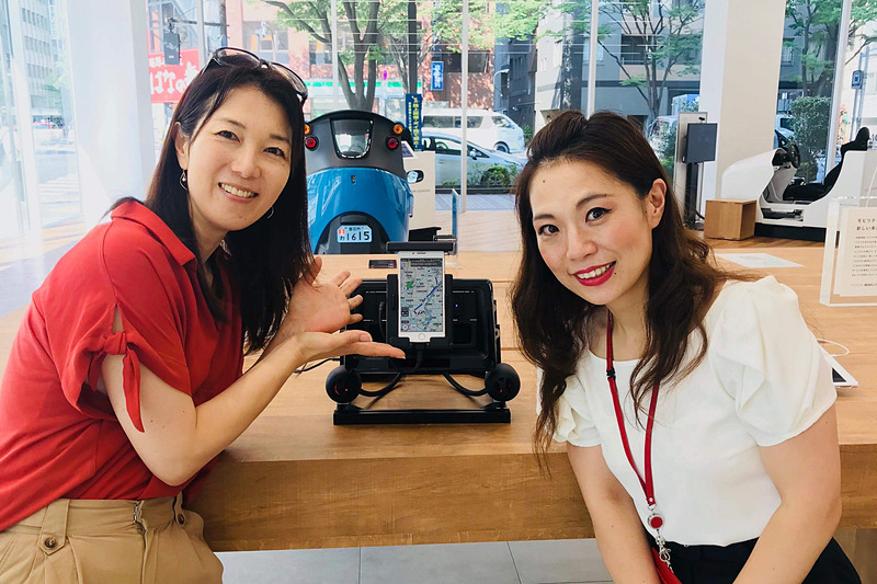 クルマに携わる仕事をする女性として、とても尊敬できるとともに共感するところも多く、明るくパワフルなキャラクターが大好きなトヨタ自動車の山田貴子さん（写真右）。今後のスマホ利用者の増加を見込んで開発した「車載マルチディスプレイホルダー」を熱く語ってくれました！