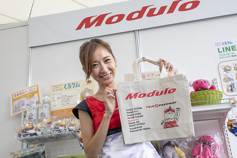 Moduloブースでは毎回、ご当地くるタムのイラストが描かれた特製バッグを用意。今回はハチマキにわさび、マフラーにウナギ、衣装にサクラエビが入ったふじタムバージョン。特定商品の購入もしくは物販で2000円以上買い物をした人にプレゼントされる