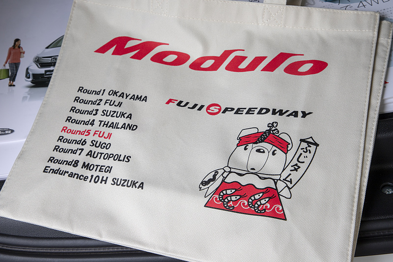 Moduloブースでは毎回、ご当地くるタムのイラストが描かれた特製バッグを用意。今回はハチマキにわさび、マフラーにウナギ、衣装にサクラエビが入ったふじタムバージョン。特定商品の購入もしくは物販で2000円以上買い物をした人にプレゼントされる