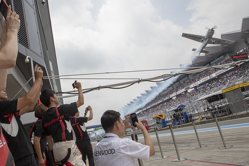 ピットで行なわれたイベントも紹介。今回のレースでは「レッドブル・エアレース・ワールドチャンピオンシップ」に参戦している室屋義秀選手のフライトがあった。室屋選手の機体が見えると、34号車のメンバーも一斉にカメラを構えた