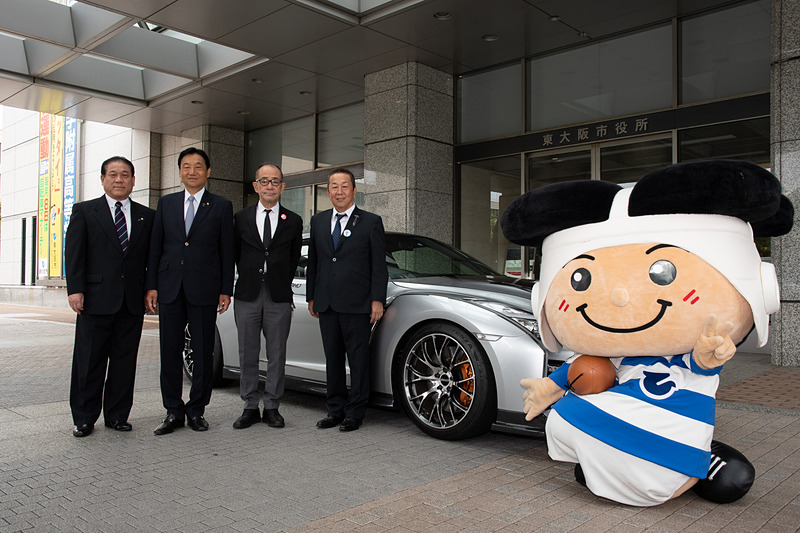 川口誠司副市長（左）とトライくんも加わり東大阪市役所前での記念写真