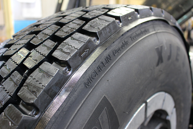 ほかの工場で製造されたトレッドゴムは、専用のビルディング機の上で裏面に接着剤としての役目を持つゴムクッションのシートを設定。シートはトレッドゴムより少し大きめになっており、タイヤのサイドウォールに貼り付けられる