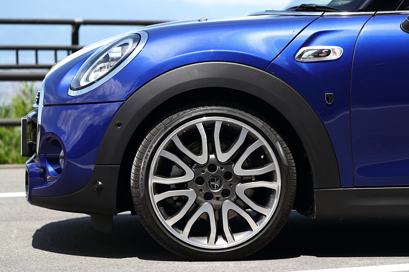 今回のマイナーチェンジでは、新しいMINIのロゴを配置するとともに、丸型ヘッドライトにはLEDのデイライト・ランニングを標準装備。テールランプにはユニオン・ジャックのデザインを取り入れ、左右非対称なデザインを採用することで個性を強調させた。足下は18インチのアロイホイールにピレリの乗用車用タイヤ「CINTURATO P7」（205/40 R18）をセット