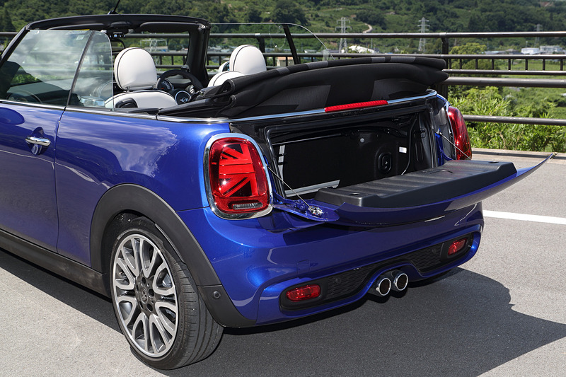 今回のマイナーチェンジでは、新しいMINIのロゴを配置するとともに、丸型ヘッドライトにはLEDのデイライト・ランニングを標準装備。テールランプにはユニオン・ジャックのデザインを取り入れ、左右非対称なデザインを採用することで個性を強調させた。足下は18インチのアロイホイールにピレリの乗用車用タイヤ「CINTURATO P7」（205/40 R18）をセット