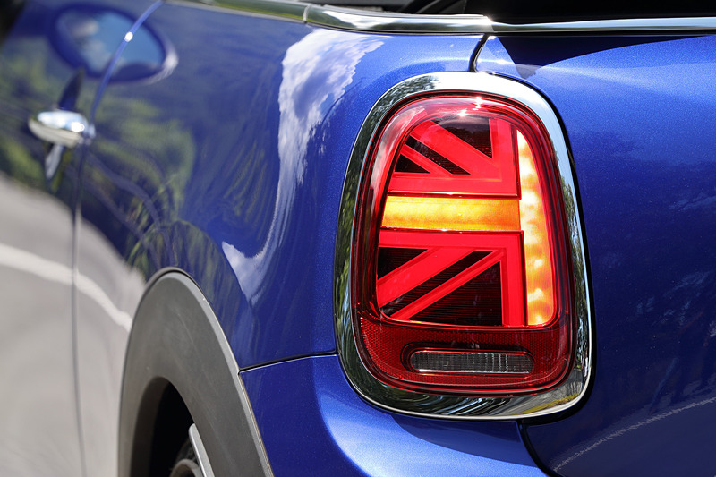 今回のマイナーチェンジでは、新しいMINIのロゴを配置するとともに、丸型ヘッドライトにはLEDのデイライト・ランニングを標準装備。テールランプにはユニオン・ジャックのデザインを取り入れ、左右非対称なデザインを採用することで個性を強調させた。足下は18インチのアロイホイールにピレリの乗用車用タイヤ「CINTURATO P7」（205/40 R18）をセット