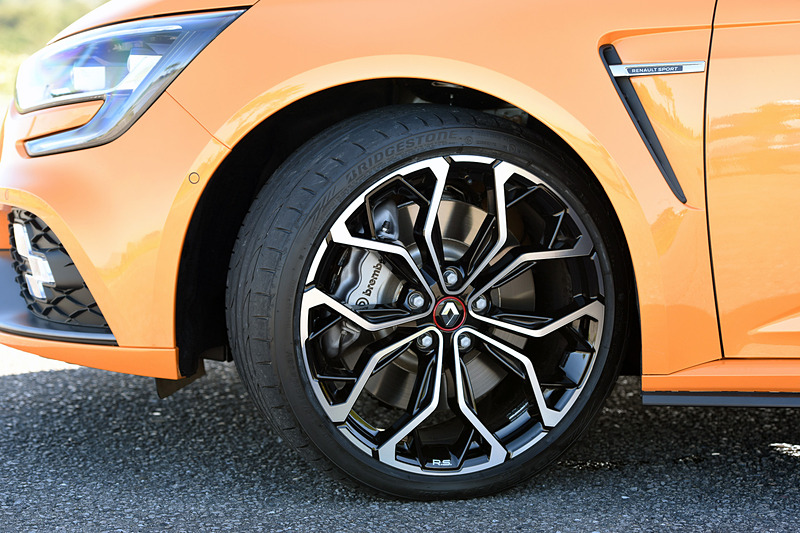 エクステリアではメガーヌ GTからフロントを60mm、リアを45mm広げたフェンダーが備わるとともに、F1スタイルのエアインテークブレードにワイドなエアインテークを組み込んだフロントバンパーを装備。スモールランプ、フォグランプ、ハイビームとしての役割を担うチェッカーフラッグ型の「R.S.ビジョン」も特徴の1つ。足まわりはカヤバ製で、タイヤはブリヂストン「POTENZA S001」（245/35 R19）