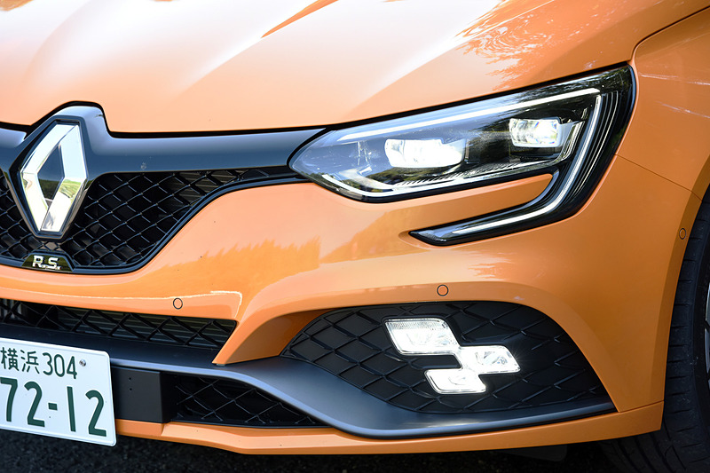 エクステリアではメガーヌ GTからフロントを60mm、リアを45mm広げたフェンダーが備わるとともに、F1スタイルのエアインテークブレードにワイドなエアインテークを組み込んだフロントバンパーを装備。スモールランプ、フォグランプ、ハイビームとしての役割を担うチェッカーフラッグ型の「R.S.ビジョン」も特徴の1つ。足まわりはカヤバ製で、タイヤはブリヂストン「POTENZA S001」（245/35 R19）