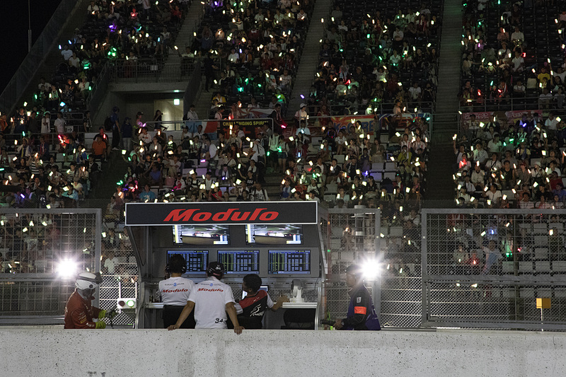 グランドスタンドはサイリウムを持ったファンでいっぱいになる。ナイトセッションがあるレースならではの光景