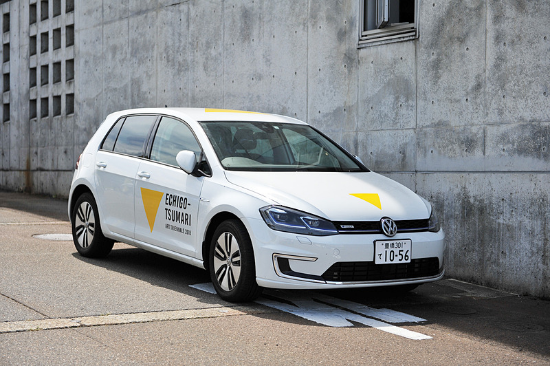 スタッフさんたちが移動に使うというオフィシャルカーを発見。グラフィックデザイナーの佐藤卓氏のデザインが施されたフォルクスワーゲンのEV（電気自動車）「e-ゴルフ」です